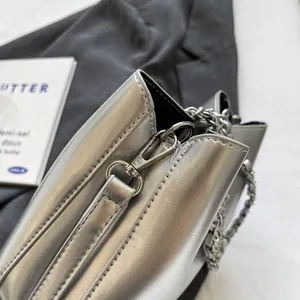 Detailed macro view of silver metallic bag featuring premium stitching and chain strap