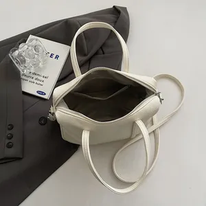Detailed interior of beige Boston bag showing rich litchi texture and inner pocket
