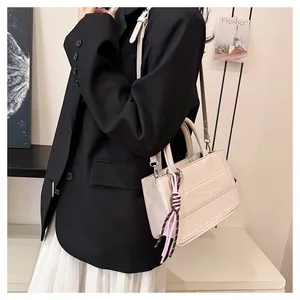 Chic beige structured tote bag with embossed lettering and decorative ribbon detail