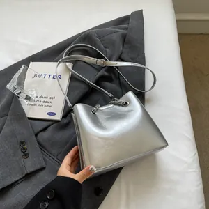 Detail of silver bucket bag featuring metallic PU leather and decorative chain strap