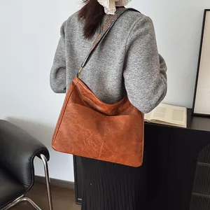 Braune Vintage Leder-Einkaufstasche mit buntem ethnisch gewebtem Schultergurt am Modell