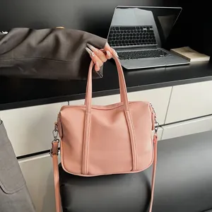 Detail of pink lychee texture leather tote with adjustable strap in office setting
