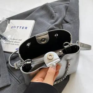 Detail view of silver tote bag interior with magnetic closure and metal chain strap