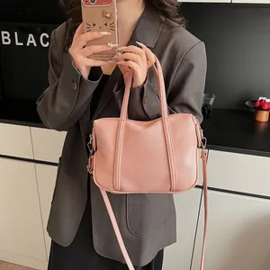 Close-up of pink lychee texture leather bag with silver hardware and detachable strap