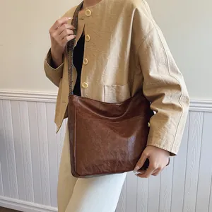 Detailansicht der braunen Leder-Eimertasche mit Retro-Struktur und Ethno-Gurt