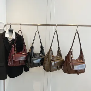 Detail view of four vintage shiny leather hobo bags in burgundy black green and brown