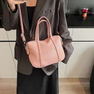 Detail view of pink lychee textured leather bag showing detachable strap and soft finish