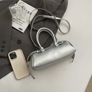 Detailed view of silver baguette bag texture on a grey suit with minimalist styling