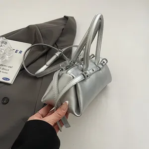 Detail of matte silver baguette bag with metallic finish and adjustable shoulder strap