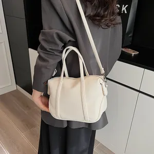 Close-up of beige lychee pattern leather handbag with adjustable strap and handles