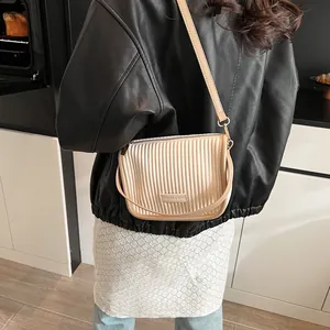 Nahaufnahme der beigen Falten-Schultertasche mit stilvollem FASHION & BAGS Logo-Metallschild