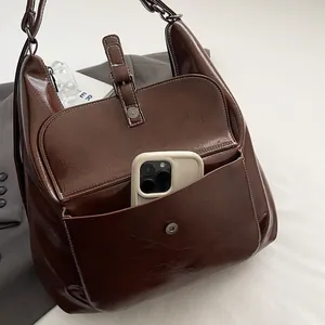 Close-up of vintage dark brown faux leather tote with front pocket and white stitching