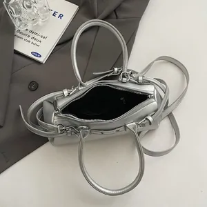 Overhead detail view of silver baguette bag showing top zipper opening and spacious interior