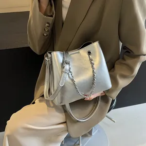 Close-up of metallic silver shoulder bag with chain strap and shiny PU finish