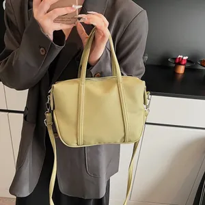 Detail showing the lychee texture of the pale green leather handbag and its strap