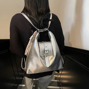 Detail of silver metallic Hobo backpack with buckle closure and woven rope accessory
