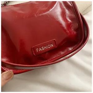 Macro shot of dark red glossy patent leather texture and Fashion label on the small bag