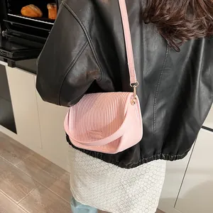 Detailaufnahme der rosa plissierten Umhängetasche mit goldener Schließe und Logo
