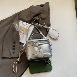 Detailansicht der silbernen Metallic-Ledertextur und des Doppelreißverschlusses der Tasche
