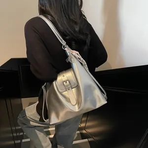 Silver mirror shoulder bag detail with strap buckle and decorative woven silk scarf