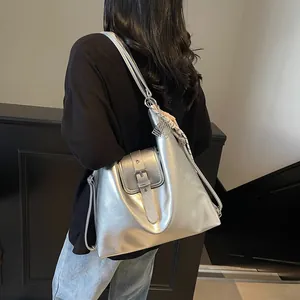 Silver metallic tote bag detail featuring magnetic flap and decorative checkered scarf