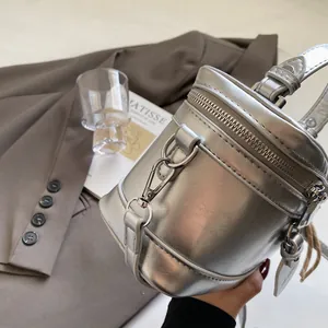Detailansicht einer silbernen zylindrischen Beuteltasche mit Spiegeleffekt und Metallreißverschluss