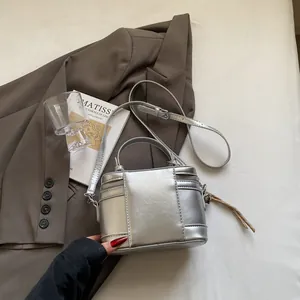 Nahaufnahme der silbernen Mini-Box-Tasche mit Metallic-Finish, Griff und Trageriemen