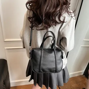Detail of black lychee grain tote bag showing dual handles and detachable shoulder strap