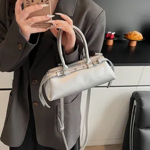 Detail of silver metallic bowling bag featuring dual handles and rivet buckle accents