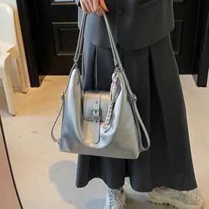 Metallic silver hobo bag with buckled flap detail and decorative knot accessory
