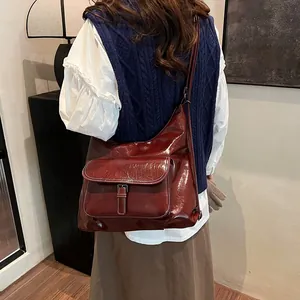Deep red vintage leather shoulder bag with a large capacity and buckle flap detail