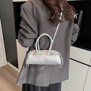 Silver metallic baguette bag with shoulder strap styled on a grey blazer for women