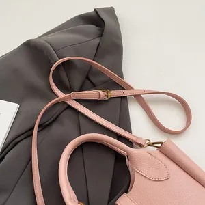 Détail du sac seau en cuir rose à grain litchi avec ferrures dorées rétro