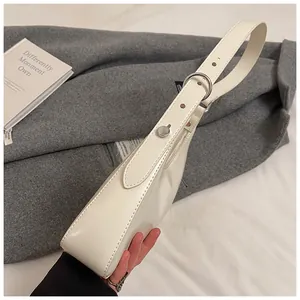 Close-up of cream PU leather armpit bag with adjustable strap and silver metal hardware
