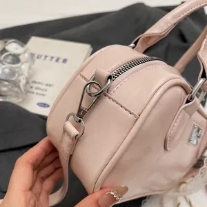 Close-up of light pink Boston bag showing silver hardware and fine leather texture