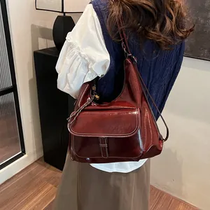Detail view of burgundy vintage hobo bag with white contrast stitching and oil wax texture