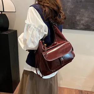 Detail of burgundy large capacity hobo bag with vintage glossy leather and buckle pocket