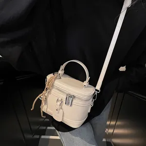 Detailansicht der cremefarbenen Box-Tasche mit Doppelreißverschluss und MEIGEFEI-Markenanhänger