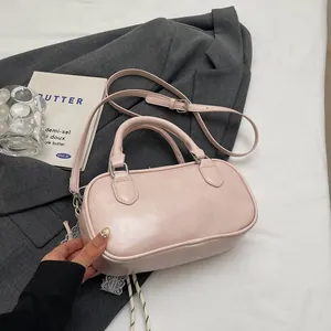 Close-up of pink Boston bag on a grey suit with elegant decorative accessories