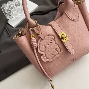 Détail du sac seau en cuir rose avec fermoir doré et breloque petit chien