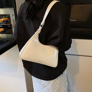 Detail of cream matte leather hobo bag with NO FILTER text and adjustable shoulder strap