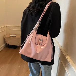Detail of pink glossy leather hobo bag with silver buckle and stylish twill scarf decoration