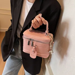 Rosa Handtasche aus Lackleder mit silbernen Beschlägen, getragen von einem Modell im Outfit
