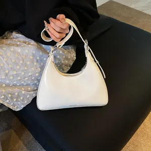 Detail of white half-moon hobo bag with No Filter text and adjustable wide strap