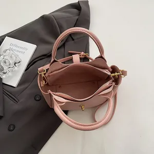 Intérieur du sac seau en cuir grainé rose avec compartiment spacieux et fermeture éclair