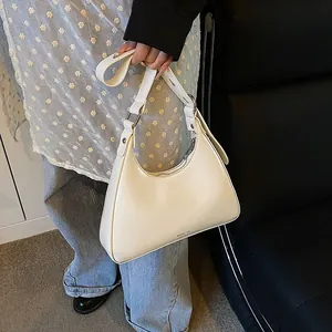 Detail of white half-moon underarm bag with NO FILTER text and silver zipper