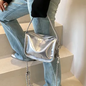 Detailed macro view of the silver metallic texture and fashion logo on the square handbag