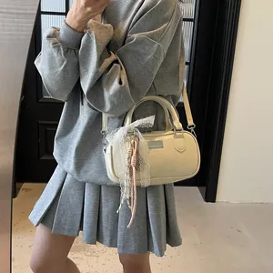 Detailed view of beige bowling bag with lace bow and woven pendant on model
