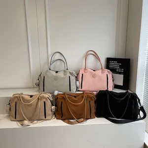 Five colors of large travel bags with shoulder straps displayed on a marble platform