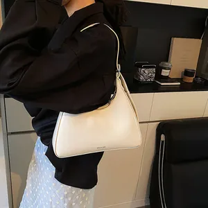 Detail shot of cream white underarm bag with NO FILTER text and smooth leather texture
